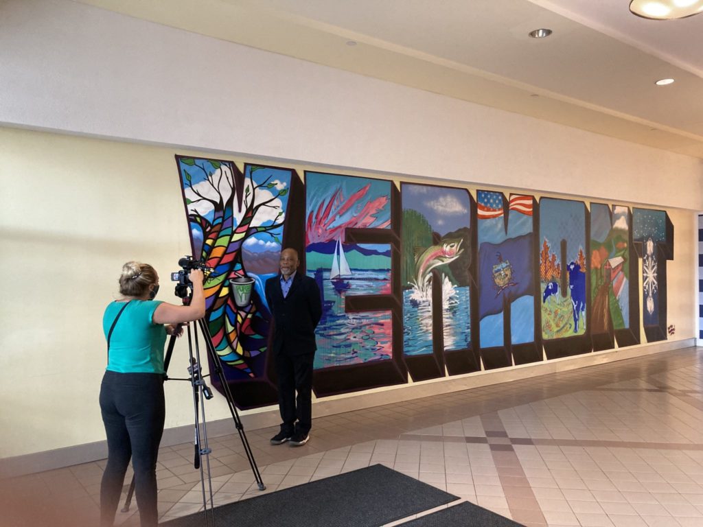 Noted Vermont philanthropist and activist Bruce Wilson is featured in front of the Vermont Arts so Wonderful mural at the University Mall in South Burlington, VT